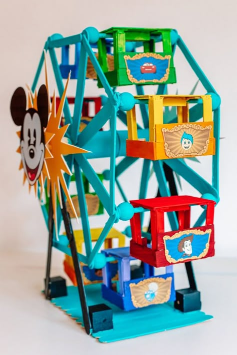 How To Make A Popsicle Stick Ferris Wheel (+ Pixar Pal-A-Round!) | studiodiy.com Popsicle Stick Ferris Wheel, Diy Ferris Wheel, Circus Bedroom, Wheel Crafts, Disney Christmas Village, Popsicle Stick Houses, Disney Craft, Disneyland Birthday, Disney Diy Crafts