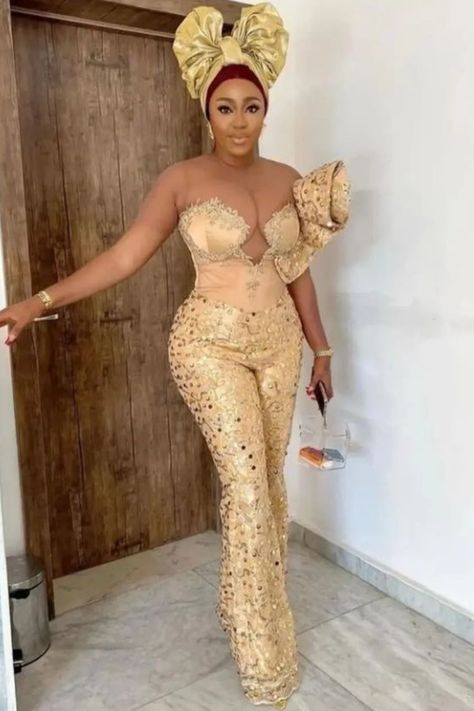 A lady wearing lace jumpsuit for wedding Lace Gown Styles 2023, Classy Jumpsuit Outfits Wedding, Lace Jumpsuit Outfit, Latest Lace Gown Styles, Asoebi Lace Styles Classy, Lace Jumpsuit Wedding, Jumpsuit Outfit Wedding, Classy Jumpsuit Outfits, Lace Asoebi Styles