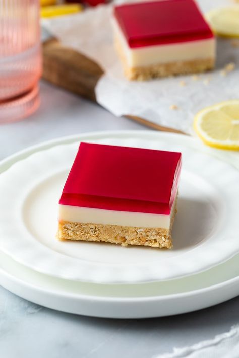 This easy jelly slice recipe is the perfect no-bake treat. A twist on classic jelly slice, it contains a buttery biscuit base and a creamy lemon and condensed milk filling; dotted with bursts of fresh blackberries and topped with luscious blackberry jelly. With just 7 ingredients and only 10 minutes of prep time, this bright, colourful and nostalgic dessert is a must-try! No Bake Slice Recipes, Jelly Slice Recipe, Jelly Dessert Ideas, Colourful Desserts, Biscuit Base Recipe, Condensed Milk Desserts, Jelly Cheesecake, Jelly Slice, No Bake Slices