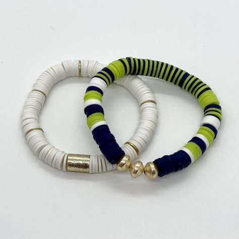 This bracelet stack is a great way to show your Team Spirit on Game Day! This is a set of two hand beaded 8mm heishi bracelets with gold accents. These stretch bracelets are fun and lightweight and can be mixed and matched for endless options. Available in many color options:- Royal Blue & White- Green & White- Black & White- Brown & White- Purple, Gold & White- Royal Blue, Yellow & White- Forest Green, Navy & White- Black, Grey & White- Green, Gold & White- B Heishi Jewelry, Heishi Bracelets, Homemade Bracelets, Dangle Bracelet, Halloween Bracelet, Black Beaded Bracelets, Polymer Clay Jewelry Diy, Clay Bracelet, Diy Bracelet Designs