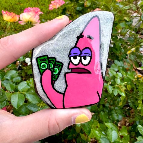 This design is painted on a tile slice. Patrick is painted with acrylic paints with a holographic glitter on the natural tile as the background. The sides are painted with a black acrylic paint. Sealed with resin for an extra glossy look.  Rocks is best kept indoors to maximize the longevity of the art. If kept outside the elements will eventually deteriorate the design/art. Cool Rock Painting Ideas Aesthetic, Trippy Rock Painting, Spongebob Painted Rocks, Spongebob Stone Painting, Cartoon Painted Rocks, Paint Rocks, Up Rock Painting, Painted Rock, Hand Painted Rocks Ideas