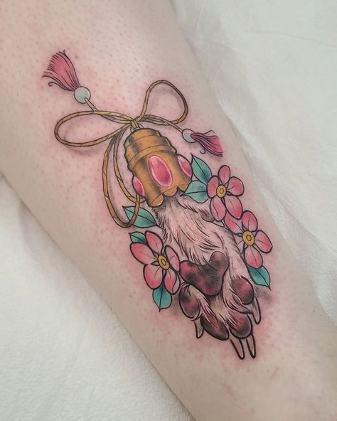 Dog paw tattoo as a lucky charm done by @kristylynneart! The floral and tassel ornaments look so pretty with those delicate colours!! What a lovely memorial tattoo idea! 😊⁠ ⁠ "Lucky puppy paw 🐾 😍 this has got to be one of my favorite tattoos I've done!"⁠ - Kristy⁠ ⁠ #dogmemorial #puppytattoo #dogpaw #pawtattoo #pettattoo #dogtattoo #memorialtattoo #colourtattoo #saskatoontattoos #yxetattoo #mamatried #mamatriedyxe #mamatriedtattoosmith Traditional Paw Print Tattoo, Dog Themed Tattoos, Paw Dog Tattoo, Colourful Dog Tattoo, Floral Memorial Tattoo, Dog Related Tattoos, Dog Cameo Tattoo, Traditional Pet Tattoo, Lucky Paw Tattoo