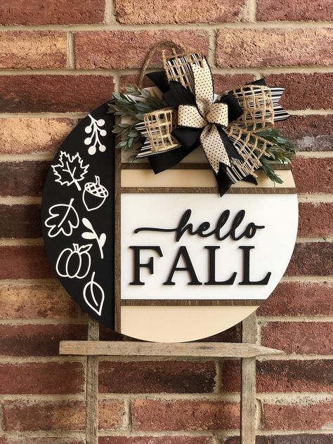 We offer a wide variety of wooden door hangers to spruce up your front door!  Description: Welcome the cozy vibes of autumn with our stunning Hello Fall Door Hanger, perfect for adding a touch of warmth and charm to your front door! Handcrafted with care, this door hanger is available in two sizes, 18" and 22", and features high-quality materials and craftsmanship. Product Features: Sizes: Choose between 18 inches and 22 inches in diameter. Thickness: Sturdy 1/2 inch thickness for durability. 3D Fall Round Wood Signs Diy, Diy Fall Door Hangers, Fall Door Signs, Welcome Wood Sign, Round Signs, Fall Door Hanger, 3d Lettering, Door Signs Diy, Craft Booth Displays