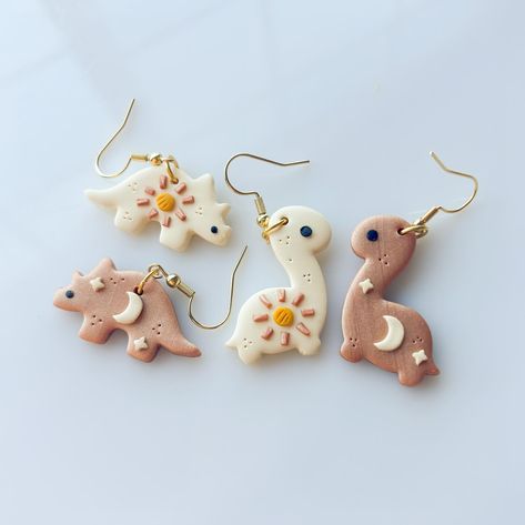 i feel like maybe everybody should consider little dino earrings👀 oops i rly love them and i hope u do too because theres like hundreds of pairs of them ONLINE ready 2 go right now !!!!! swipe to see ‘em all!! 12 designs in brontosaurus and triceratops ➡️➡️➡️ Dino Earrings, Clay Making, How To Make Clay, Cute Clay, Jewelry Charms, Feel Like, Charms, I Hope, Ceramics