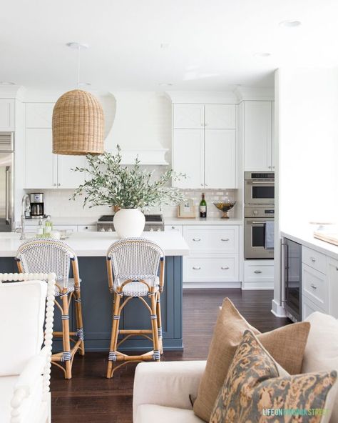 Gorgeous white kitchen with a blue island, basket pendant lights, Serena & Lily barstools, and olive branches for greenery. #home #homedecor #kitchendecor Serena And Lily Kitchen, Gorgeous White Kitchen, Basket Light, Basket Pendant, Olive Leaves, Olive Branches, Bistro Style, White Subway Tiles, Serena Lily