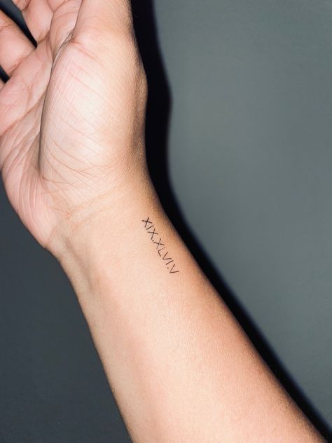 Bible verse translated to Roman numerals; XIX.XLVI.V and used for wrist tattoo Bible Verse Tattoo On Wrist, Psalm 113:3 Tattoo, Small Roman Numeral Tattoo Wrist, Wrist Tattoos Bible Verse, Tiny Bible Verse Tattoos, Pslam91 Tattoo, Psalm 30:5 Tattoo, 46:5 Psalm Tattoo, Psalm Tattoo Ideas