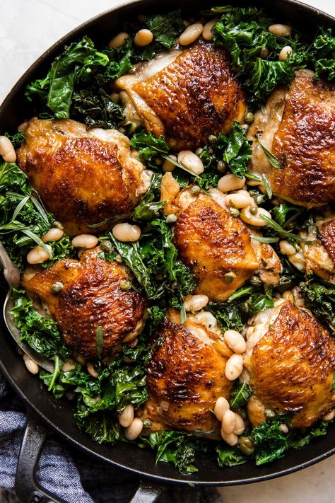 Crispy seared chicken thighs get a slow braise alongside kale and creamy white beans. The whole healthy mess is finished with briny capers and fresh tarragon in this easy one-pot chicken dinner. Dutch Oven Chicken Thighs, Dutch Oven Chicken, Braised Chicken Thighs, Pan Chicken Recipes, The Modern Proper, Modern Proper, One Dish Dinners, One Pot Chicken, Oven Chicken