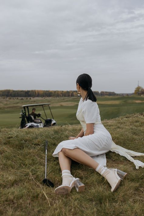 Woman in White Dress Sitting on Green Grass and Waiting for Golfer · Free Stock Photo Sitting On Grass Poses, Sitting In Grass Poses, Fall Portrait Photography, Photo Studies, Pose Picture, Woman In White Dress, Grass Drawing, Sitting Pose Reference, Sneakers Drawing