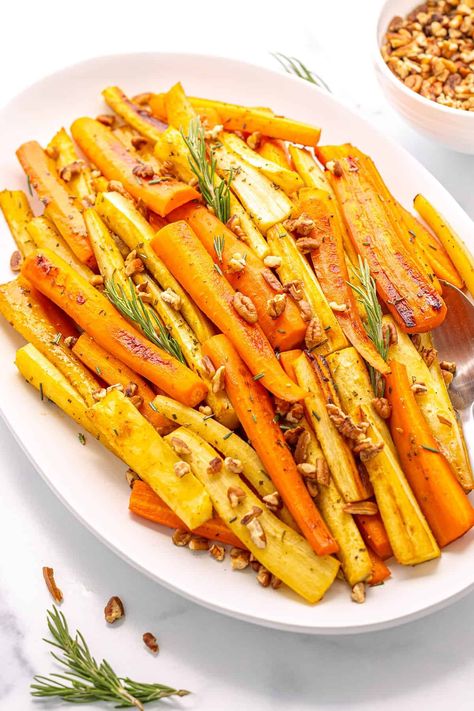 A large white platter with carrots and parsnips topped with fresh rosemary and chopped pecans on a white counter top. Glazed Carrots And Parsnips, Sweet Glazed Carrots, Fall Side Dishes, Fall Side Dish Recipes, Honey Roasted Parsnips, Red Skin Mashed Potatoes, Carrots And Parsnips, Roasted Carrots And Parsnips, Fried Brussel Sprouts