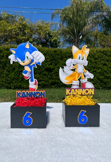 "Sonic Centerpiece **Option \"image cut out\" (Double image sided w/clear stick)- 1 CHARACTER **Option \"Image cutout w/name\" (Double sided image w/clear stick & name)-1 CHARACTER **Option \"Cutout full set\" (Double sided image w/clear stick, name, age )-1 CHARACTER CENTERPIECE: * Price above is for one centerpiece (Includes age on box) * Centerpiece includes base wood box * Image is double sided, name is not double sided * Centerpiece dimensions: width 6\"- height 15.5\" * Base box dimensions : width 6\" height 4\" * Colors can be customized at your request :) * If selected wording on centerpiece includes name  * If you would like to add wording, there will be an additional charge. ⁕Please message me before placing your order if you would like to make changes. ✨ Don't see what you're lo Sonic Centerpieces, Sonic Birthday Decorations, Sonic Party Favors, Little Mermaid Centerpieces, Sonic Birthday Party, Hedgehog Party, Box Centerpiece, Sonic Birthday Parties, Shadow Sonic