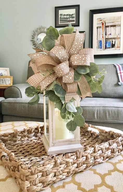 Decorating a coffee table is a snap with a woven tray, lantern, and a lantern swag with eucalyptus. A large burlap bow is the perfect lantern decor for a living room. #LanternDecor #FarmhouseLanternSwag #Etsy Lantern Wreath Centerpiece, Decorating Lanterns Ideas, Decorated Lanterns Ideas, Lantern Bows How To Make, Decorate With Lanterns, Spring Lantern Decor Ideas, Diy Lantern Decor, How To Decorate A Lantern, Spring Lantern Decor