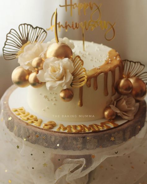 Celebrate your special moments with a touch of gold! This stunning anniversary cake, adorned with metallic spheres, white flowers, and gold accents, is the perfect blend of elegance and sweetness. Whether it's for an anniversary, birthday, or any special occasion, let us craft a custom cake just for you! Ready to order? Message me on WhatsApp at 7044955912 and let's make your event unforgettable! #TheBakingMumma #AnniversaryCake #ElegantCakes #GoldAccents #CustomCakes #HomeBaker #OrderNow White And Gold Anniversary Cake, First Wedding Anniversary Cake, Anniversary Cake Aesthetic, First Anniversary Cake, Gold Anniversary Cake, Cake Aesthetic, Wedding Anniversary Cake, First Wedding Anniversary, Elegant Cakes