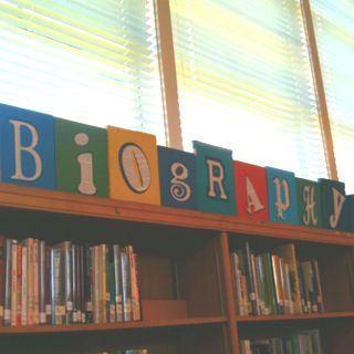 Sign for biography section of my library made with discarded books and book pages. I cut the letters from the pages and a dark blue. I glued these to the front of the books and then used Gorilla glue to glue the books to a 1x4. Last step was to screw two books onto the end to hold the sign up. Middle School Library, School Library Decor, Library Signage, School Library Design, School Library Displays, Middle School Libraries, Library Book Displays, Library Posters, Elementary School Library