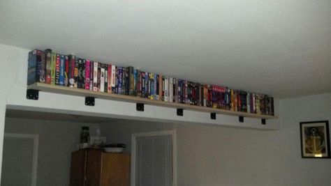 New shelf to display our VHS collection. A poplar 1x6 and 7 l-braces we spray painted black. Great use of that 'unusable' beam in the middle of our room! Vhs Display Ideas, Vhs Organization Ideas, Vhs Room Decor, Movie Collection Shelf, Vhs Shelf, Vhs Ideas, Movie Shelf Ideas Dvd Storage, Vhs Display, Peewee's Playhouse