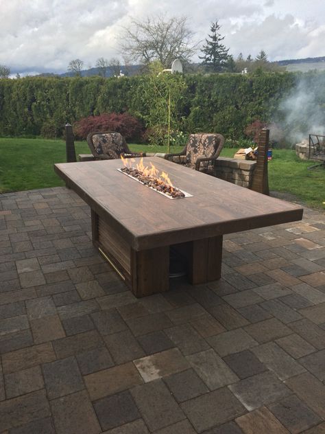 Outdoor dining table.  This is  8'x4', and has a 4' fire trough.  The top is made of porcelain floor tiles that look like wood. Diy Table With Fire Pit In Middle, Outside Table Ideas, Fire Tables Outdoor, Table With Fire Pit, Diy Outdoor Dining Table, Diy Outdoor Dining, Outside Tables, Fire Pit Dining Table, Outdoor Fire Table