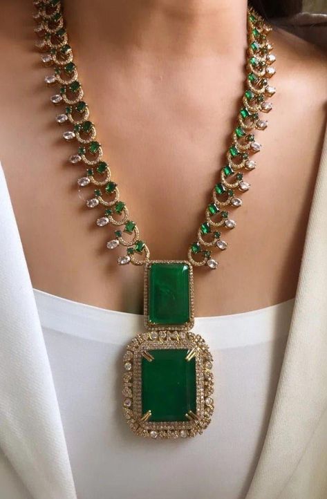 Sabyasachi Mukherjee's designs, this exquisite Victorian long necklace set with earrings encapsulates opulence and tradition in every detail. Crafted in a rich shade of emerald green, the doublet necklace features intricate embellishments that evoke the grandeur of Victorian-era jewelry. The necklace itself is a masterpiece of craftsmanship, adorned with delicate filigree work, sparkling crystals, and meticulously placed pearls. Each element is carefully chosen to reflect the luxurious aesthetic synonymous with Sabyasachi's creations, blending vintage charm with contemporary flair. The matching earrings complement the necklace perfectly, featuring cascading drops of green doublets surrounded by miniature pearls and crystals. Together, they create a harmonious ensemble that exudes sophistic Stones Jewellery Necklace, Antique South Indian Jewellery, Victorian Jewellery Designs, Emerald Necklace Indian, Long Neckless, Crystal Necklace Designs, Long Kundan Necklace, Victorian Jewelry Necklace, Cord Earrings