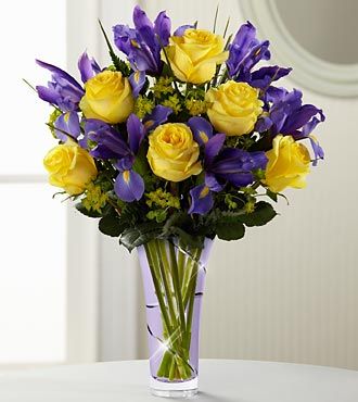 The FTD® Touch of Spring® Bouquet is a blossoming expression of spring sweetness. Sunlit yellow roses are arranged beautifully amongst deep purple iris and lush greens, perfectly pressented in a lavender designer glass vase to create a warm sentiment of limitless charm and beauty. Cemetery Arrangements, Roses Yellow, Wedding Colors Purple, Fleurs Diy, Cemetery Flowers, Church Flowers, Yellow And Purple, Spring Bouquet, Mothers Day Flowers