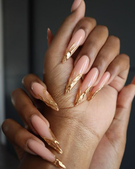 When I see these stunning nude and gold-tipped nails, I instantly think of a luxurious night out or a classy event where first impressions matter. The swirl of metallic gold elevates the classic nude to new heights, making it perfect for anything from a chic dinner party to an elegant wedding. Nail Inspiration Gold Foil, Dubai Inspired Nails, Gold Pattern Nails, Sparkle Gold Nails, Gold Tips Nails Acrylic, Clear Stiletto Nails Design, Gold Chrome Nails Designs Almond, Double French Tip Nails Almond, Nude And Chrome Nails