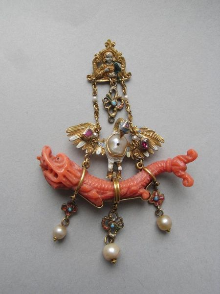 Pendant, Venice, late 16th century. Gold; enamelled and jewelled; shaped, pierced plaque; Virgin(?) with chalice; quatrefoil pendant at base between two chains attached to pelican in her piety with jewelled wings and baroque pearl for breast; below: dragon in coral attached by loops from which hang three quatrefoils with pearl at base of each. 16th Century Jewelry, Baroque Jewelry, Bracelet Viking, Historical Jewellery, Medieval Jewelry, Coral Jewelry, Ancient Jewelry, Jewelry Style, Viking Jewelry