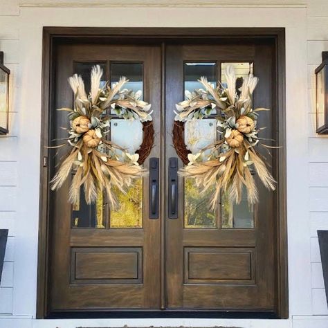 This beautiful fall wreath will be the perfect touch for your door, double doors, columns, wall, etc. Wreath is made on a grapevine base and packed full of quality faux pampas, lambs ear, natural pumpkins and more. Shown in the 18" grapevine base. The blue door is 35" wide. Double door wreaths will be made mirrored.  14" base Dimensions: Wreath grapevine base 14" Height approx 28" Width approx 22" Depth approx 8" 18" base Dimensions: Wreath grapevine base 18" Height approx 34" Width approx 26" D Fall Double Door Wreaths, Double Door Fall Wreaths, Brown Front Doors, Barn Door Decor, Magnolia Decor, Fall Front Door Decor, Faux Pampas, Double Door Wreaths, Wreath Pumpkin