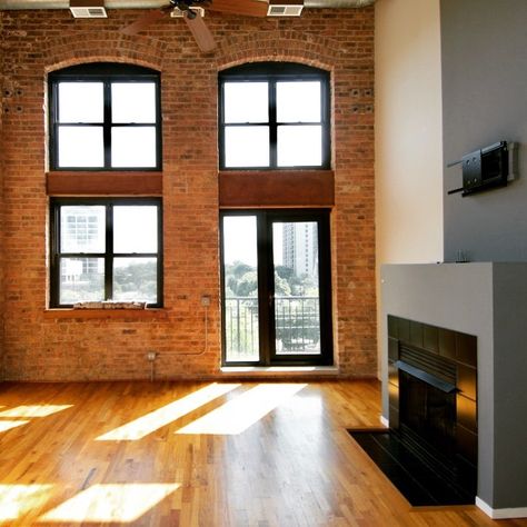 Loft apartment for rent in Chicago with lovely high ceilings, natural light and fantastic factory windows. Private balcony off living room in Chicago loft apartment that also features a gas burning fireplace, hardwood floors and exposed brick walls. | Domu Chicago Apartments Downtown Loft Apartments, Exposed Brick Condo, Loft Apartment Chicago, Brick Apartment Aesthetic, Loft Apartment Brick, Brick Loft Apartment Aesthetic, Brick Loft Apartment, Chicago Apartment Aesthetic, Exposed Brick Loft