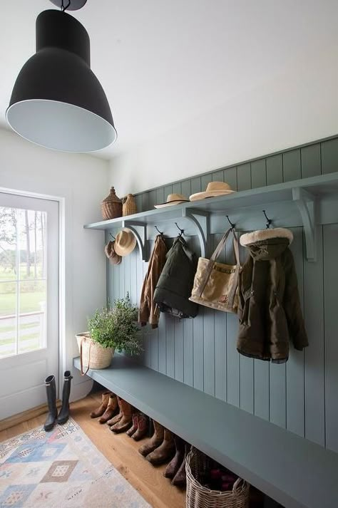 A blue mudroom bench is fixed against blue shiplap trim under oil rubbed bronze hooks fixed beneath a blue shelf. Boot Room Coat Hooks, Hallway Boot Bench, Coat Rack Hallway, Country Boot Room, Beadboard Coat Rack Wall, Narrow Boot Room, Boot Room Ideas Entrance, Lakehouse Mudroom, Mudroom Walls