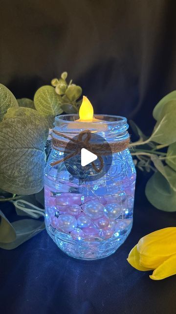 Claire | SisterPledge on Instagram: "Turning simple into stunning! 💍✨ 

DIY wedding decorations for my daughter’s big day in May! Recycled jam jars, fairy lights, water gel beads, floating pearls, and battery tea lights make for magical garden table settings. 

#DIYWeddingDecor #MotherOfTheBride" Fairy Light Jar Ideas, Glass Jar Lanterns, Tea Light Table Decorations, Water Gel Beads, Cylinder Centerpieces, Fairy Jars Diy, Fairy Lights In A Jar, Battery Tea Lights, Gel Beads