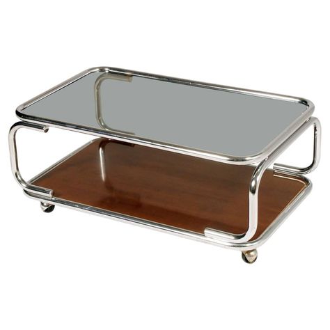 This mid-century coffee table was produced in Italy in the 1960s. It features a chromed metal base on casters and a smoked glass top on faux laminated wood. Adjustable Height Coffee Table, Geometric Coffee Table, Modern Wood Coffee Table, Wood For Sale, Serving Trolley, Coffee Table Trunk, Mid Century Coffee Table, Oval Coffee Tables, Nesting Coffee Tables