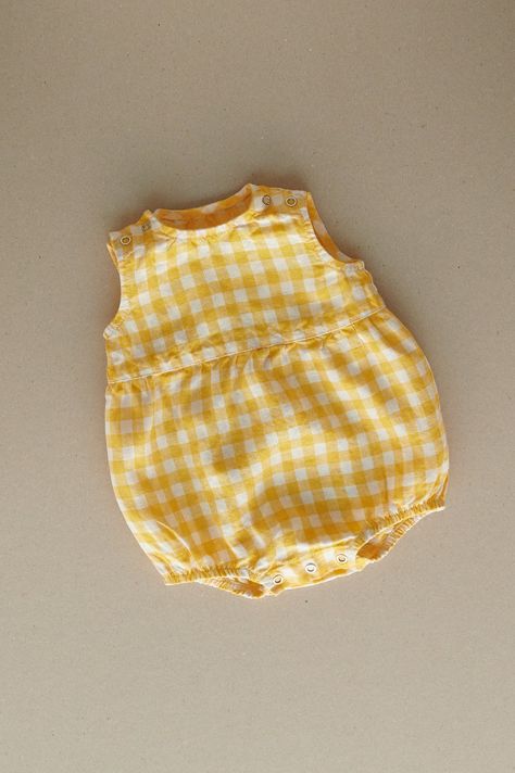 Product photos - yellow gingham. All-day comfort is guaranteed with this sleeveless romper crafted from gingham linen. The fabric is soft, breathable, and light on the skin. For simple changing, the romper is designed with popper snap fastenings on the shoulders and bottom. The waist seam in the middle adds a nice final touch to an adorable silhouette, and elasticated leg cuffs secure the romper in place. This baby romper is designed to be comfortably loose-fitting and allow for growth as the baby grows. Linen Baby Clothes, Baby Romper Outfit, Vintage Kids Clothes, Gingham Linen, Yellow Gingham, Frocks For Girls, Cute Rompers