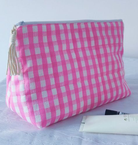 This roomy and easy to make make-up bag will have you sewing one for everyone you know! I love that it has a flat bottom, zipper top and then widens at the bottom so it will stand with ease. It is also quilted and will offer added protection for all those breakables.It's a perfect size to take away for the weekend or even longer trips...it can hold it all! Watch the full tutorial on YouTube. These are the materials needed. Pin the outer fabric to wadding and then sew on the wa… Quilted Makeup Bag Tutorial, Makeup Bag Tutorials, Makeup Bag Pattern, Cosmetic Bag Pattern, Diy Makeup Bag, Homemade Makeup, Bags Tutorial, Makeup Bags, Diy Makeup