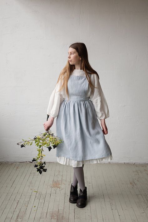 Traditional apron made from 100% soft and washed linen. Details: - Composition: 100% Oeko-Tex certified linen - Colour: baby blue - Pockets - Cross back - Adjustable with buttons - Size: One size - Medium weight linen - Linen care: machine wash gentle; tumble dry low, ironing optional - The price is for one pinafore dress, other pictured items are not included Measurements: Length from waist down: 65 cm (25,5 in) Chest width: 24 cm (9,4 in) Waist width: 72 cm (28,3 in) Pocket size: 20x25 cm (7,9 Victorian Aprons, Linen Pinafore Dress, Linen Pinafore Apron, Traditional Aprons, Linen Pinafore, Apron Cooking, Apron For Women, Pinafore Apron, Carl Larsson