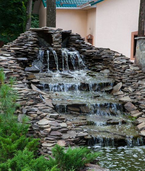 A large multi-level waterfall water feature made of loosely layered black slate stones. There was no concrete used to construct this and only relies on gravity and the weight of each piece of rock to hold them together. The flat slate stones used are perfect for creating a gentle water terrace. Water Terrace, Stone Water Features, Small Front Gardens, Garden Water Feature, Fountains Backyard, Garden Waterfall, Front Garden Design, Pond Landscaping, Waterfall Wall