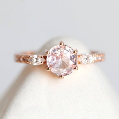 Lola 💕 the prettiest peach sapphire captured in a lovely setting with marquise side diamonds and pave band. Needless to say we’re in love 😍 how about you? DM us for pricing✨ Side Diamond Engagement Ring, Engagement Ring Pink, Peach Sapphire Rings, Pink Sapphire Diamond Ring, Marquise Cut Diamond Ring, Peach Sapphire Engagement Ring, Grey Diamond Ring, Pink Engagement Ring, Pink Sapphire Ring Engagement