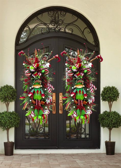 xtra Large Christmas Elf Wreath for Double Doors | Nice Elf Christmas Theme Swag For Front Door | Red, White, Gold Christmas Decor Merry Christmas, Happy Holidays, and a Happy New Years everyone! Introducing a brand new elf swag. This wreath has a large red sparkly bow, made with both red ribbon and white/ green ribbon with a white and black satin pattern in the center. This ribbon is about 4 inches thick. On the top of this swag are various sparkly picks in gold, red and light green to match the elf suit. In the center there are different colored ornaments all red, green, and white. A beautiful stuffed elf man in the center with two reflective gift box ornaments on the side. To match the top, on the bottom is the same red  bow and a different all satin ribbon with the same white, green an Christmas Door Decorations Outdoor, Wreaths For Double Front Doors, Elf Christmas Theme, Outdoor Wreaths On House, Double Door Christmas Decor, White Gold Christmas Decor, Front Door Christmas Garland, Red White Gold Christmas, White Gold Christmas