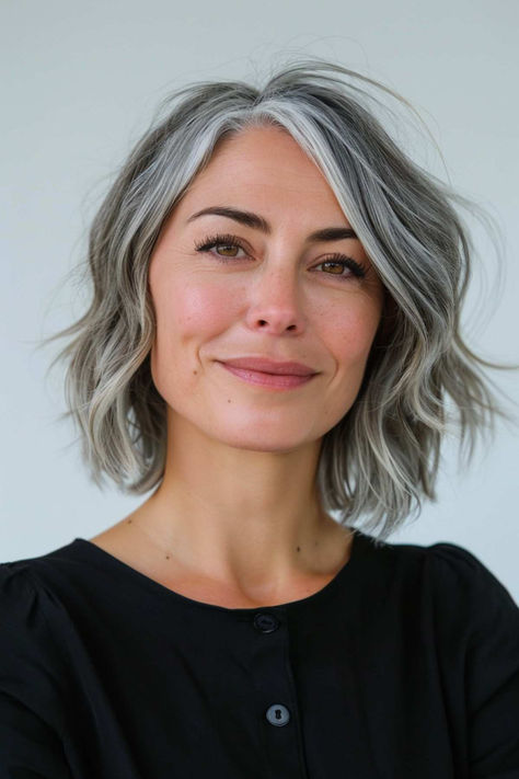 Short wavy bob with natural grey highlights, offering a fresh and stylish look. Short Grey Hair Highlights, Grey Streak Hair, Grey Short Haircut, Gray French Bob, Grey Roots Growing Out, Wavy Grey Bob, Short Bob Grey Hair, Grey Hair Bob Hairstyles, Grey French Bob