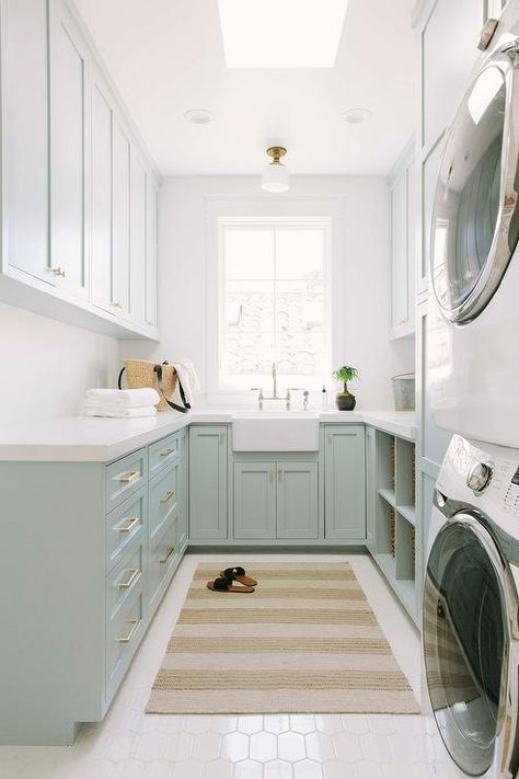 Blue green u-shaped laundry room boasts a beige striped rug placed on white hex floor tiles beneath a skylight. Madison Ct, Laundry Room Storage Shelves, White Laundry Rooms, Green Laundry, Room Storage Diy, White Laundry, Mudroom Laundry Room, Laundry Room Inspiration, Small Laundry