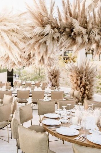 DESIGN | NgLp Designs shares decorating ideas with Pampas Grass ~ “The tall, wheat-colored tufted grasses have a soft, wispy quality that add instant texture ~  bundles of pampas grass were attached to a trellis above neutral tabletops and linen-covered chairs, which allowed the pampas to really pop ... | neutral decor, organic, neutral, natural hues, wedding trends, party decor, floral accents, floral arrangements  ///  #floralarrangements #florals #weddingdecor #grasses Hanging Pampas, Floral Clouds, Pampas Grass Decor, Beige Wedding, Grass Wedding, Flower Installation, Clouds Design, Neutral Wedding, Neutral Decor