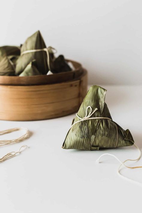 A pyramid shaped Chinese sticky rice dumpling zhongzi tied with string. Chinese Sticky Rice, 5 Spice Powder, Chinese Mushrooms, Rice Dumplings, Chinese Spices, Salted Egg Yolk, Marinated Mushrooms, Pyramid Shape, Lean Pork