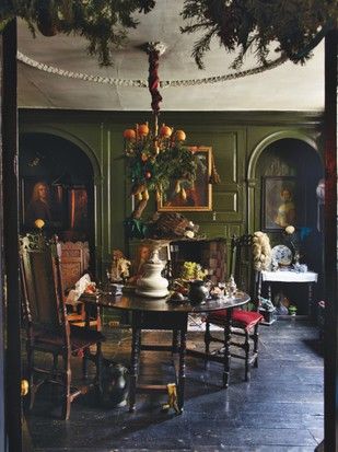 The dining room in Dennis Severs' House with a dark wood table, dark green walls, oil paintings and a chandelier adorned with greenery and oranges Green Dining Room Walls, Georgian Christmas, Dining Room Victorian, Green Dining Room, Victorian Parlor, Georgian Homes, House Inside, Dining Room Walls, Designers Guild