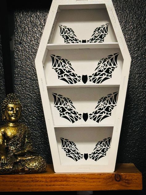 This Lacey bat Coffin Shelf is the perfect addition to any Gothic-themed space. Handmade with high-quality wood and Mdf Wood, this shelf is both sturdy and stylish. The black color and decorative style make it a unique piece of home décor, perfect for displaying your favorite items. perfect for displaying crystals or trinkets  15x3.5x8 inch shelf Comes in different styles Coffin Bookshelf, Kawaii Forest, Coffin Shelf, Bat Decor, Forest Room, Crystal Shelf, White Goth, Moody Decor, Crystal Shelves