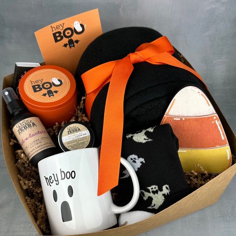 My gift boxes make the perfect gift! Each box measures 10"x10"x6", is tied with a black ribbon and is ready to give as a gift to that special person. Gift box includes: (1) 8 oz natural, hand poured, soy candle in orange tin in your choice of scent (1) custom box of matches (1) 50"x60" black fleece blanket (1) pair of halloween socks (1) halloween 12 oz coffee mug (1) halloween candy corn wooden sign (1) 2 oz linen spray in your choice of scent (1) small pumpkin pie lotion bar (1) custom greetin Gift Basket Ideas Halloween, Halloween Gift Baskets For Adults, Small Pumpkin Pie, Adult Boo Basket, Trick Or Treat Gifts, Halloween Hostess Gifts, Cake Gift Basket, Scary Gift, Boo Baskets