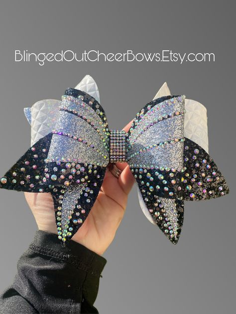 "PLEASE READ Black, white and silver cheer bow.  Price per bow is $20, you can customize the colors only if you are ordering 10+ bows, otherwise you will purchase the bow in the photos. For team orders of 10+ bows you can choose up to 3 colors total for the bow.  You can choose colors for the top loop, top tail, middle layer and back tail along with the iron on glitter vinyl. All bows with have the rhinestone detail.  These are SS10 AB rhinestones Rhinestone cheer bow//competition cheer bow//bli Silver Cheer Bows, Cheerleader Girls, Competition Cheer, Hat Jewelry, Bling Bows, Rhinestone Crafts, Time Lord, Cheerleader Girl, Competitive Cheer