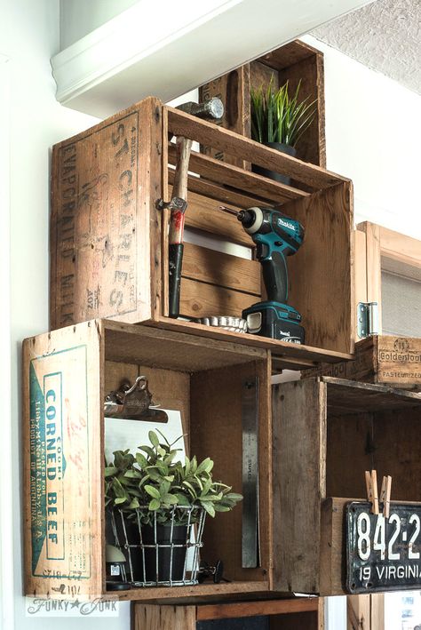 Stacked vintage crates and a reclaimed wood shelf for a rustic kitchen phone station against white walls. | funkyjunkinteriors.net Fruit Crate Shelves, Wood Crates On Wall, Vintage Crates On Wall, Crates Above Kitchen Cabinets, Antique Crate Decor, Vintage Crate Bookshelf, Wood Crates Shelves, Crate Wall Display, Wood Crate Shelves On Wall