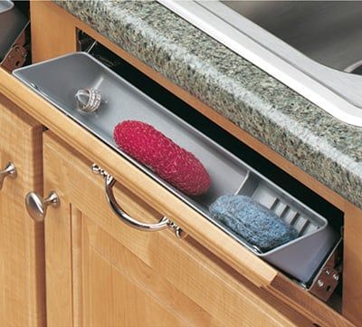 A sink tilt-out tray is used in place of false drawer fronts under a sink. The area is used to store small items, such as sponges, wash cloths, and hand soap. A sink tilt-out tray is a small storage area between the cabinet frame and the bowl of the sink. This area is usually wasted,... Under Sink Drawer, Under Kitchen Sink, Kitchen Sink Cabinet, Under Kitchen Sink Organization, Kitchen Sponge Holder, Kitchen Sink Organization, Sink Shelf, Bath Organization, Under Sink Storage