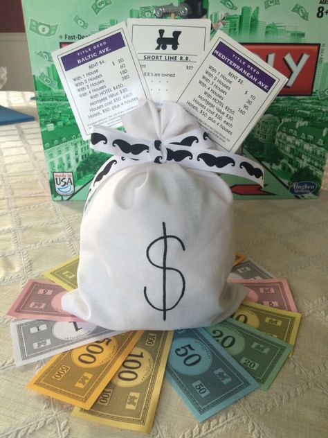 Monopoly centerpiece by my sister-in-law for my brother's 40th birthday party - picture only: half ball styrofoam and stuffing inside bag, mustache-themed ribbon, Monopoly game cards with game piece hot glued to dowel, sitting on fan of Monopoly money Monopoly Party Theme, Monopoly Birthday Party, Monopoly Birthday Party Ideas, Board Game Party Theme Decor, Monopoly Centerpiece, Monopoly Themed Party Decor, Monopoly Party Ideas, Board Game Theme Party, Monopoly Themed Party