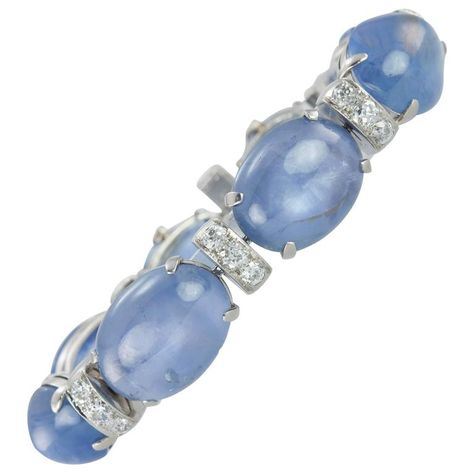 1930s Seaman Schepps Sapphire Cabochon Diamond Platinum Bracelet. A stunning Seamen Schepps Art Deco platinum line bracelet from circa 1930s. This striking bracelet consists of 24 Old European Cut diamonds (approximately 3.60 carats in total diamond weight) set on roundel style links that alternate with sapphires. The beautiful blue hues of the natural, no-heat sapphire cabochons slightly graduate in size to the largest center cabochon sapphire. The 8 sapphires total approximately 100 carats. Seaman Schepps, Sapphire Cabochon, Platinum Bracelet, Vintage Designer Jewelry, Antique Bracelets, Swarovski Bracelet, Weight Set, Platinum Jewelry, Art Nouveau Jewelry