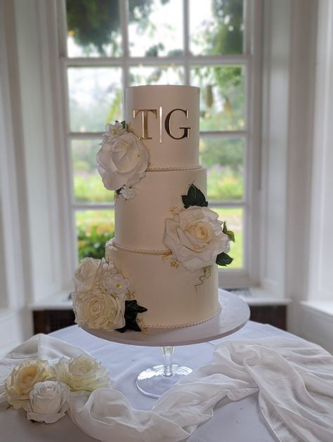 3 tier wedding cake Elegant & glamerous finish with gold initials and white blooms Www.babycakesguildford.co.uk Three Tier Buttercream Wedding Cake, 3 Tier Wedding Cake Elegant, White Floral Wedding Cake, Wedding Cake Elegant, 3 Tier Wedding Cake, Cake Elegant, 4 Tier Wedding Cake, White Floral Wedding, 3 Tier Wedding Cakes