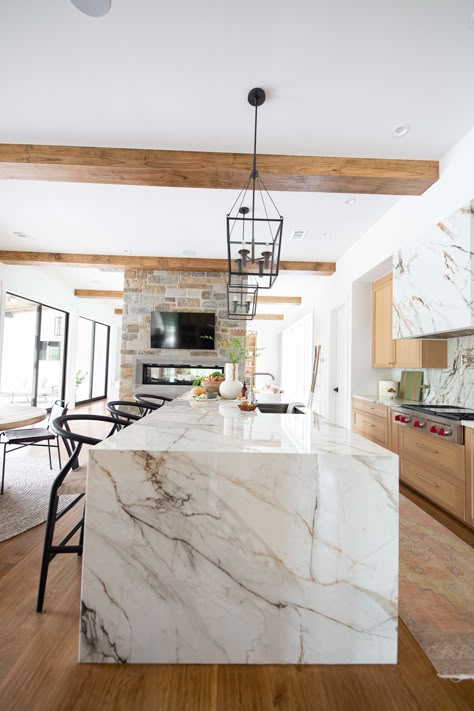 Waterfall Island With Cooktop, Two Tone Island Countertop, Statement Island Countertop, Porcelain Waterfall Island, Half Waterfall Kitchen Island, Brown Kitchen Cabinets With White Quartz, Quartz Island Waterfall, Waterfall Granite Island, Light Stone Countertops