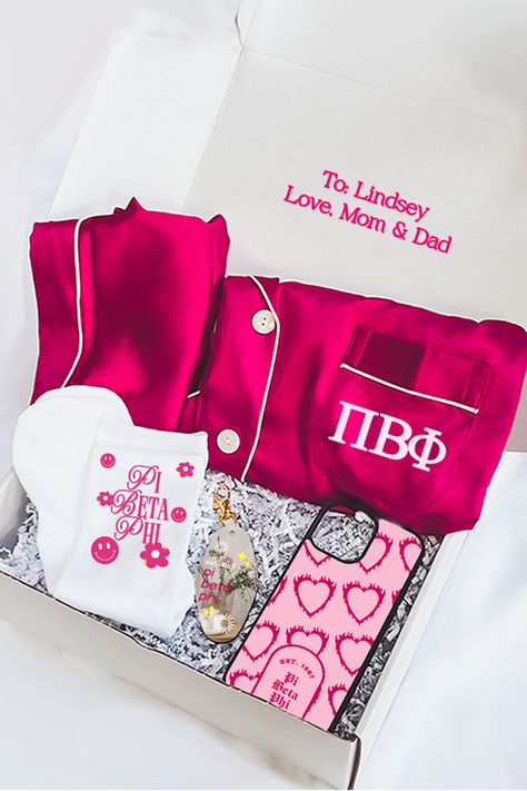 Our pink berry sorority gift box includes: - Luxuriously soft personalized satin pajama set printed with your sorority letters- Sorority keychain printed on both sides with gold hardware- Pair of one size fits most polyester fabric sorority socks- Sorority iPhone case - Box size = 12" x 9" x 4" Your custom gift message is printed on the box in pink text. Colors may slightly vary due to different screen settings.Pajama Care - turn pajamas inside out, machine wash cold on delicate and tumble dry l Sorority Keychain, Sorority Pajamas, Sorority Baskets, Big/little Baskets, Little Gifts Sorority, Letters Sorority, Big Little Basket, Senior Night Gifts, Sorority Letters