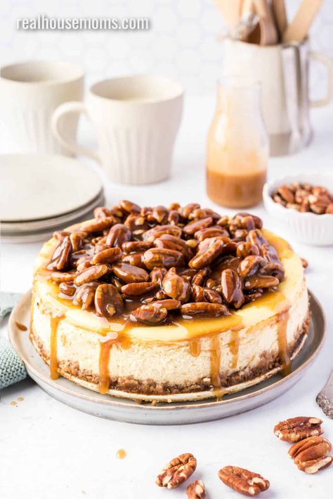 Creamy cheesecake topped with pecans in luscious caramel sauce! Pecan Pie Cheesecake is dessert perfection and everyone will ask for the recipe! #RealHousemoms #pecan #cheesecake #pecancheesecake #dessert #thanksgiving #holidays #copycatrecipe Caramel Pecan Cheesecake Recipes, Pecan Cheesecake Recipes, Pecan Pie Cheesecake Recipe, Caramel Pecan Cheesecake, Apple Crisp Cheesecake, Cinnamon Cheesecake, Cinnamon Filling, Pecan Pie Cheesecake, Pecan Cheesecake